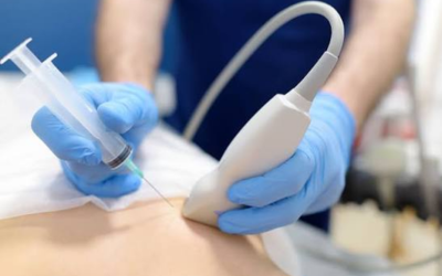 Â___biopsy | dr. Vipulroy rathod | dr. Vipulroy rathod Healthcare professional in blue gloves guiding a needle with an ultrasound probe to deliver an injection on a patient.