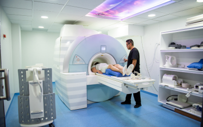 Â___ct mri or pet scans | dr. Vipulroy rathod | dr. Vipulroy rathod Patient lies on MRI table entering a large cylindrical MRI scanner with a technician standing nearby in a clinical room.