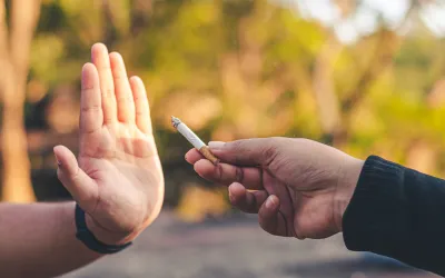 _ smoking | dr. Vipulroy rathod | dr. Vipulroy rathod Person holding a vaping device or cigarette toward another person who raises an open hand in a stop gesture, signaling refusal or boundary.